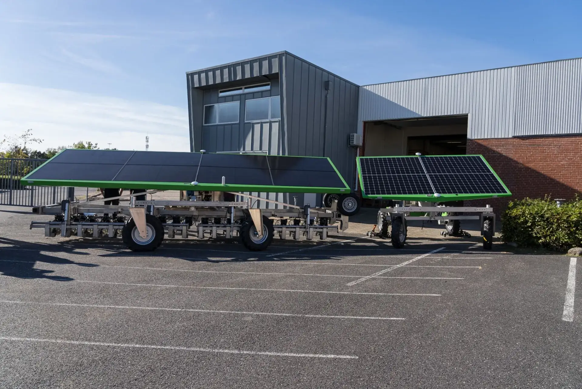 FarmDroid FD60 and FD20 robots parked side by side outside a building